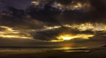 Body of Water Under Gray Sky at Golden Hour