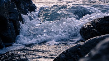 Body of Water Waving Between Rock Formation