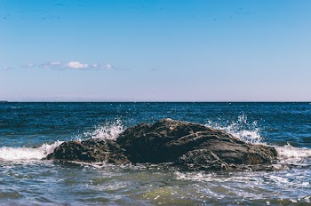 Body of Water With Black Rock