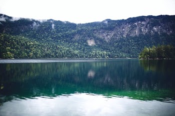 Body of Water With Green Mountain at Distance