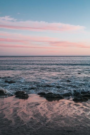 body of water with pink sky