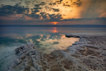 Body of Water With Reflections of Clouds during Sunset