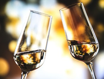 Bokeh Photo of Two Toast Clear Glass Wine Glasses