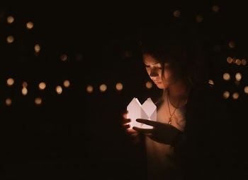 bokeh photography of woman holding paper lantern