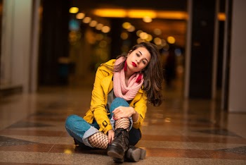 Bokeh Photography of Woman Sitting on Brown Flooring