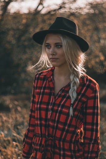 bokeh photography of woman wearing trilby hat and sports shirt