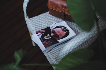 book on white wicker armchair