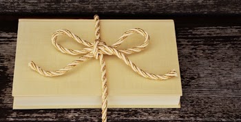 Book Tied With Rope on Black Wooden Surface