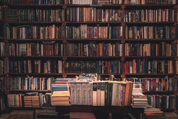 Books on Wooden Shelves Inside Library