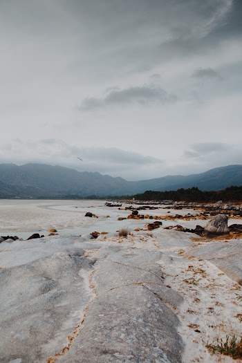 Boulders and Sand Under Gray Sky