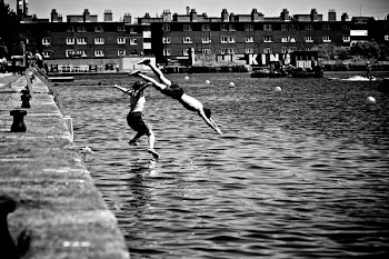 Boy and Girl Jumping in Body of Water