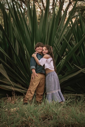 Boy And Girl Standing Near Green Leafed Plants