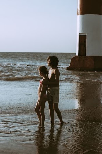 boy and girl standing on near the lighthouse