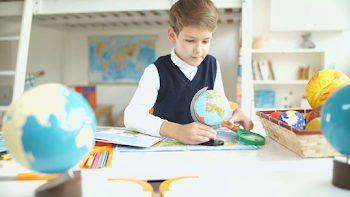 Boy and globe. An inquisitive boy studying globe. A schoolboy ...
