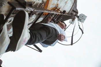 boy climbing on metal ladder