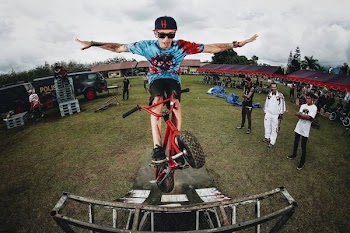 boy doing bicycle tricks in front of many people