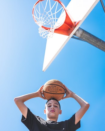 Boy Holding a Basket Ball On His Head