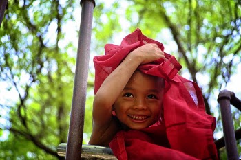 Boy Holding Red Textile Covering His Head
