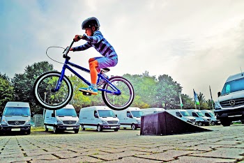 Boy in Black Nutshell Helmet on Blue Bmx Bike Having Hangtime After Taking Off on Ramp
