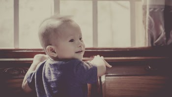 Boy in Blue Crew Neck Shirt Standing in Front of Window