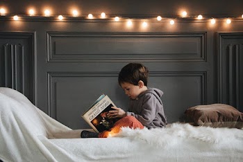 Boy in Gray Jacket Reading Book