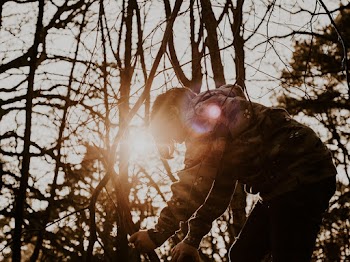 boy in Hoodie Picking Up Dried Twigs in Woods