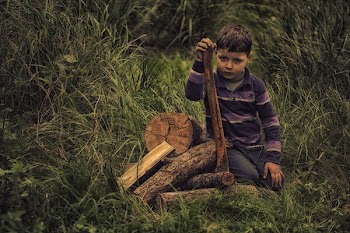 Boy in Purple Stripe Print Long Sleeve Shirt Holding Wooden Rod on Green Grass Field