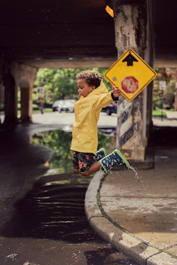 Boy Jumping from Road Curb