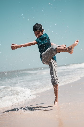 Boy Kicking Sand On Shore