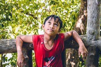 Boy Leaning On Fence