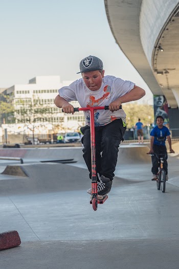 Boy on Red and Black Scooter Suspended in Air
