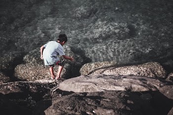Boy Playing With Stick Near Water