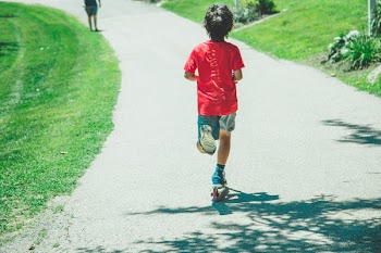 Boy Riding Scooter on Street
