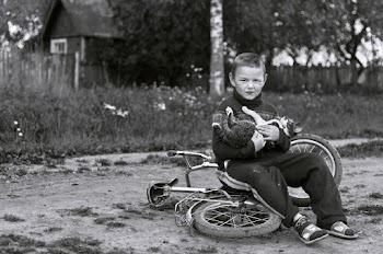 Boy Sitting on Bike While Holding Cat
