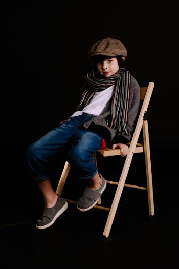 Boy Sitting on Brown Chair