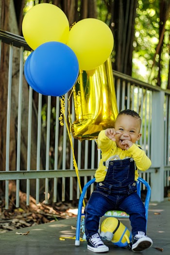 Boy Sitting on Chair Tied with Balloons