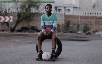 Boy Sitting on Vehicle Tire