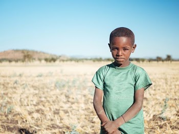 boy standing and holding his arm