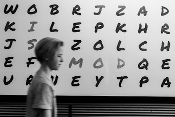 boy standing in alphabet board