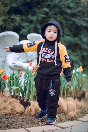 Boy Standing Near Angel Statue