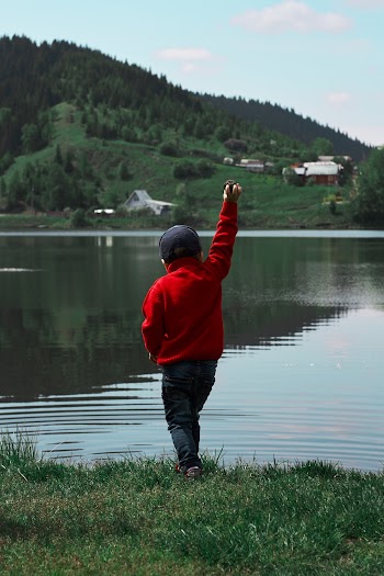 Boy Standing Near Body Of Water