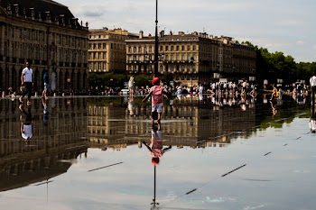 Boy Walking Near the Brown Building