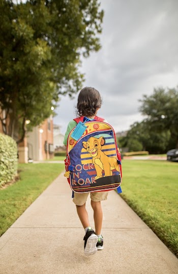 Boy Walking on Paved Pathway Wearing Backpack 