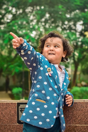 Boy Wearing Blue and White Polka-dot Blazer Pointing