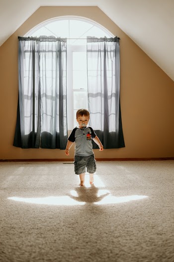 Boy Wearing Gray T-shirt and Gray Cargo Shorts Inside White Painted Wall Room