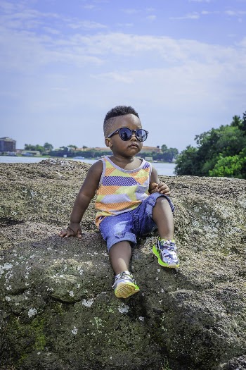 Boy Wearing Sunglasses Sitting on Rock