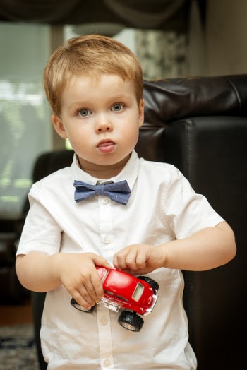 Boy Wearing White Collared Button-up Shirt Holding Red Vehicle Toy