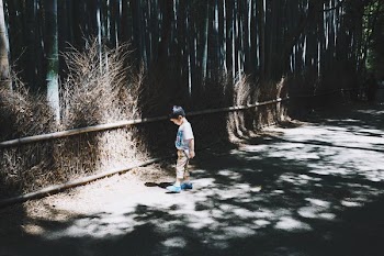 boy wearing white top standing on gray concrete floor