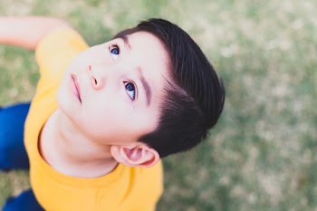 Boy Wearing Yellow Crew-neck T-shirt and Blue Bottoms Outfit Looking Above