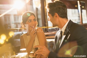 Boyfriend proposing to surprised girlfriend in restaurant